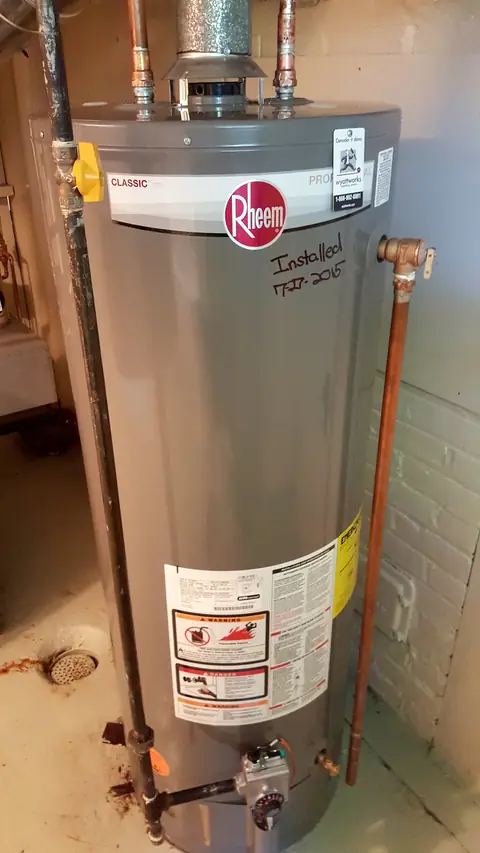 A newly installed gas tank water heater in a utility room